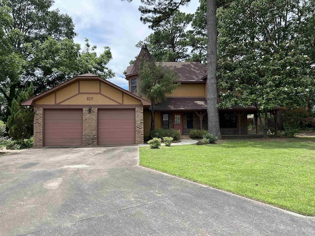 view of front facade featuring brick siding, a front lawn, concrete driveway, stucco siding, and an attached garage