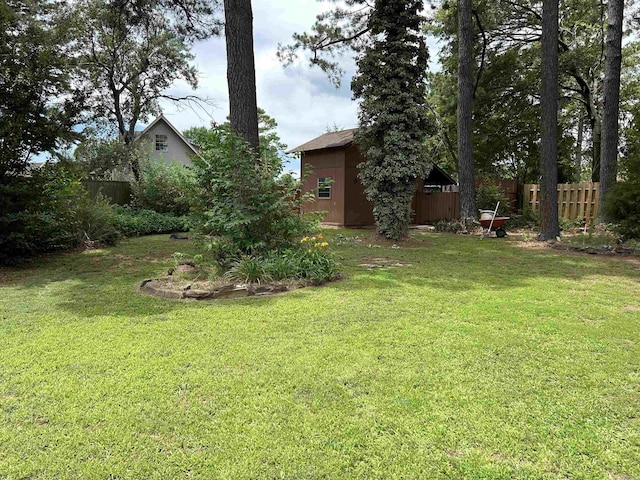 view of yard featuring an outdoor structure and fence