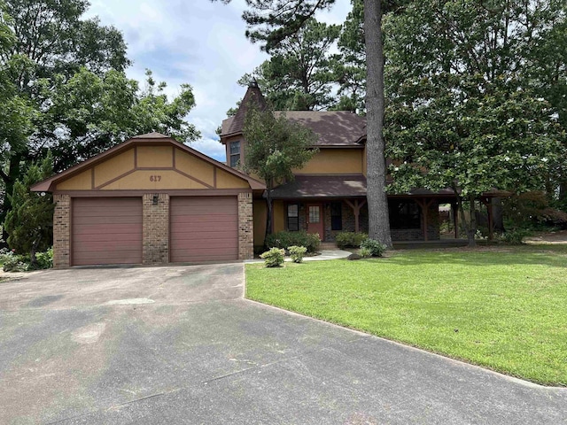 view of front of property featuring stucco siding, driveway, a front yard, a garage, and brick siding