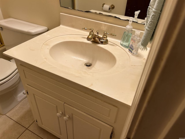 half bath featuring toilet, vanity, and tile patterned flooring