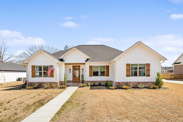 modern inspired farmhouse with crawl space, board and batten siding, a front yard, and a shingled roof