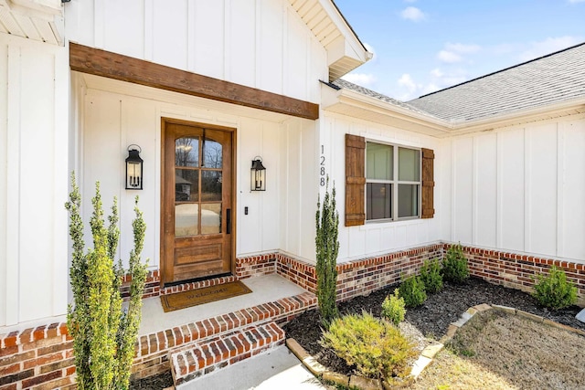 doorway to property with roof with shingles and board and batten siding