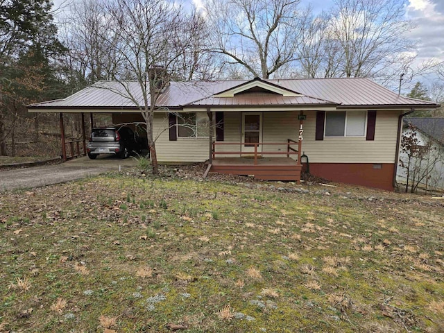 ranch-style house featuring an attached carport, covered porch, driveway, and metal roof