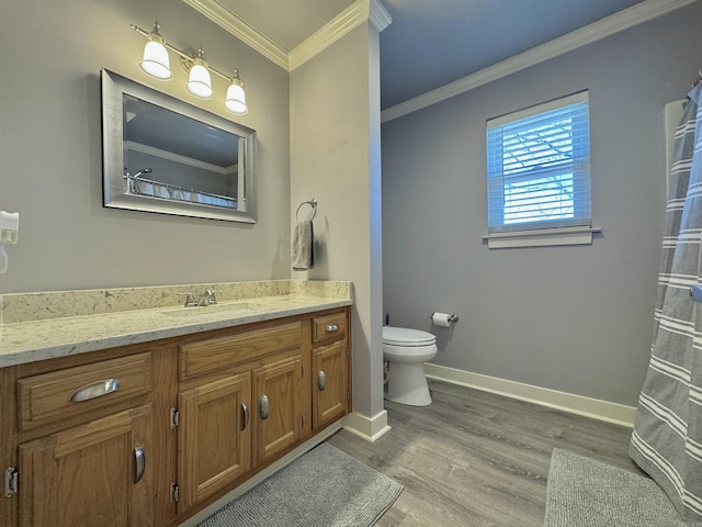 full bath featuring vanity, wood finished floors, baseboards, crown molding, and toilet