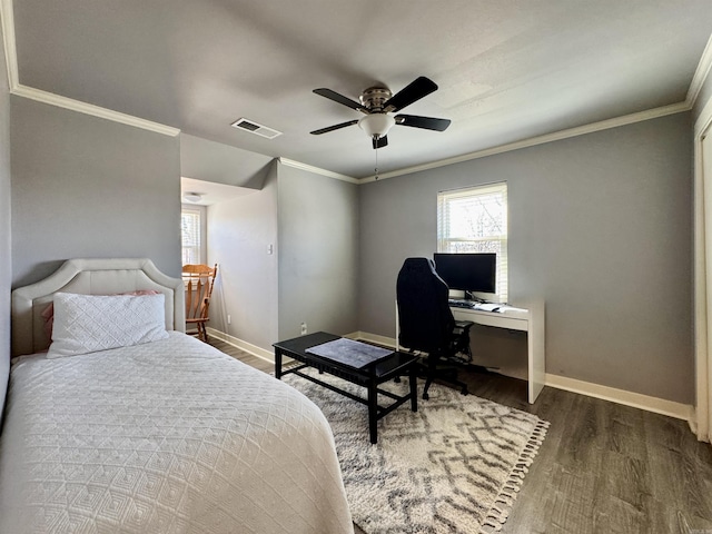 bedroom featuring visible vents, crown molding, ceiling fan, baseboards, and wood finished floors