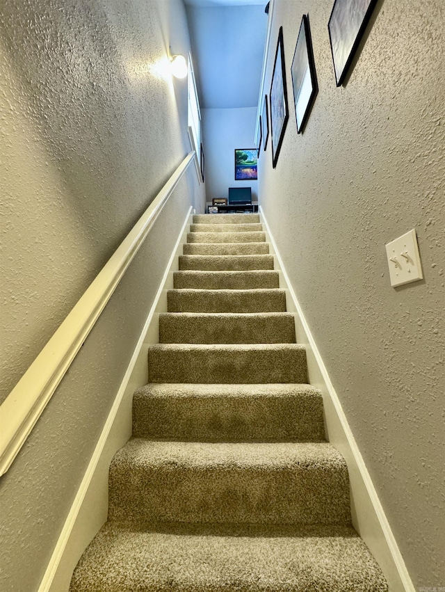 stairway featuring a textured wall