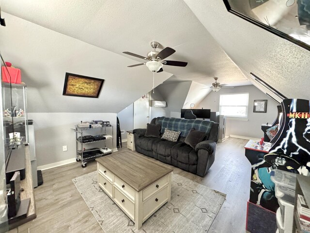 living room with baseboards, light wood finished floors, and a textured ceiling