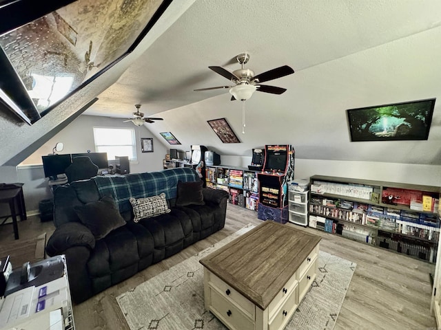 living room with a textured ceiling, wood finished floors, and vaulted ceiling