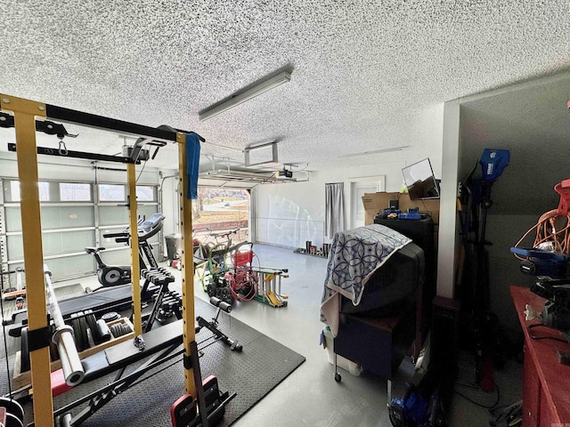 workout area featuring a garage and a textured ceiling