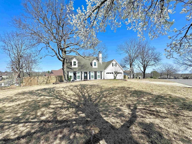 view of front of home with a chimney, a front yard, and fence