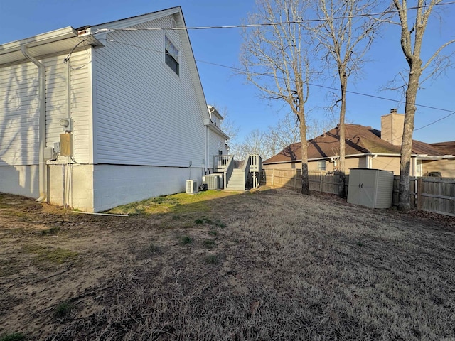 view of home's exterior with stairway, cooling unit, and a fenced backyard