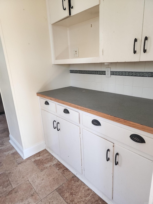 interior details with baseboards and tasteful backsplash