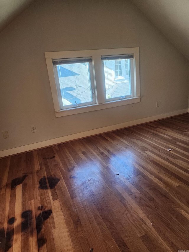 bonus room with baseboards, lofted ceiling, and wood finished floors