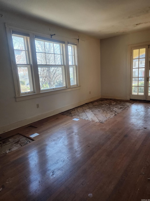 empty room featuring baseboards and wood finished floors