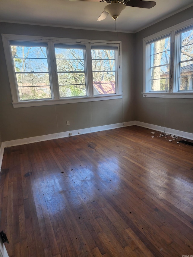 unfurnished room with ceiling fan, ornamental molding, baseboards, and dark wood-style flooring