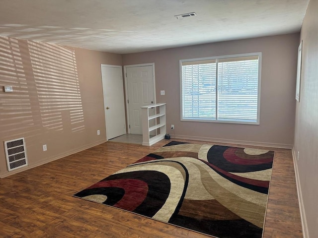 interior space with visible vents, baseboards, and wood finished floors