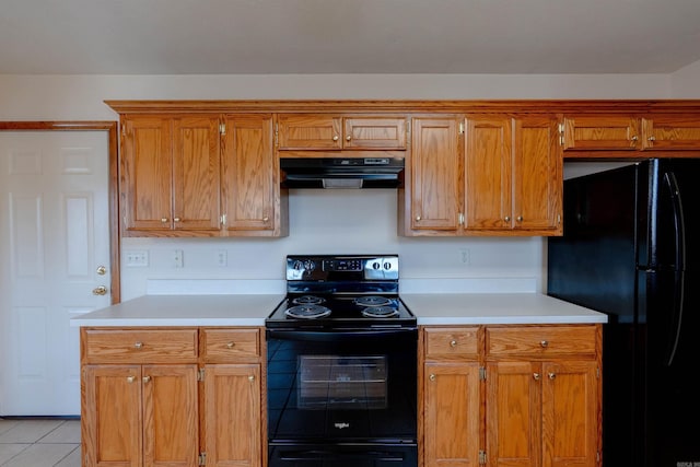 kitchen with under cabinet range hood, brown cabinetry, black appliances, and light countertops