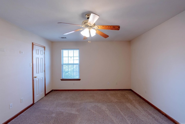 empty room with visible vents, baseboards, carpet floors, and a ceiling fan