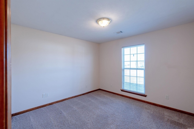 carpeted empty room featuring visible vents and baseboards