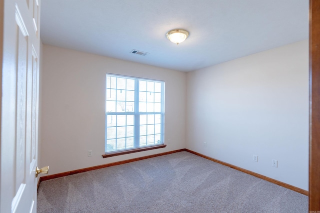 carpeted empty room with visible vents and baseboards