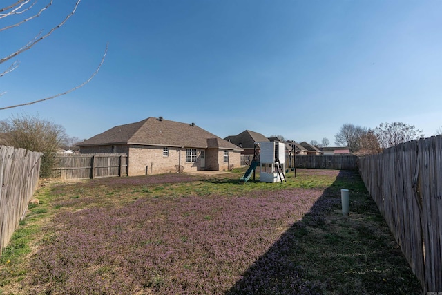 view of yard featuring a playground and a fenced backyard