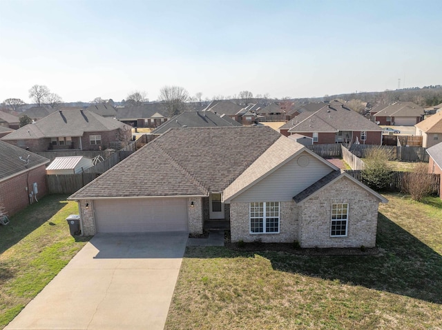 view of front of home featuring a residential view, an attached garage, concrete driveway, and a front yard