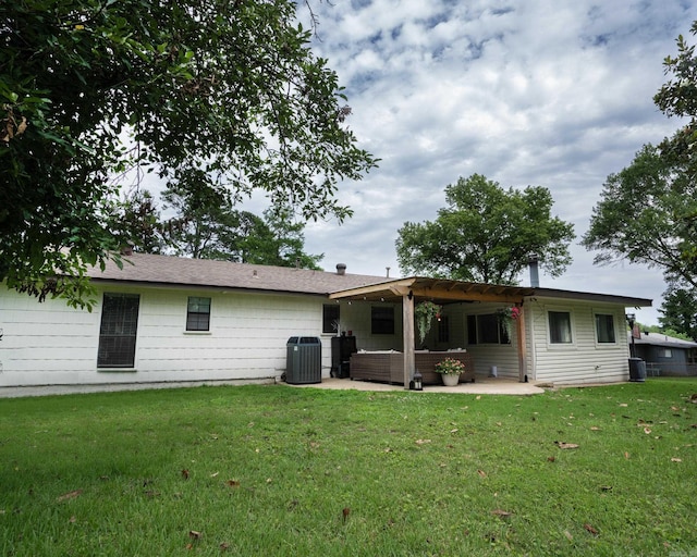 rear view of property with a lawn, central AC, and a patio area