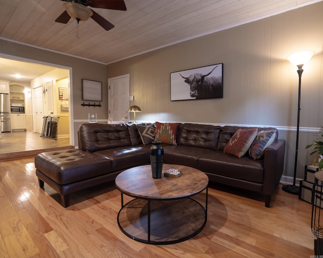 living room with built in features, a ceiling fan, light wood finished floors, wood ceiling, and crown molding