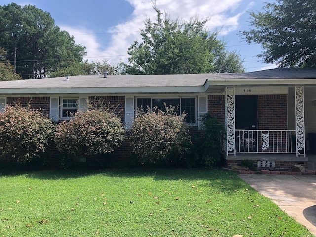 ranch-style home featuring brick siding, covered porch, and a front lawn