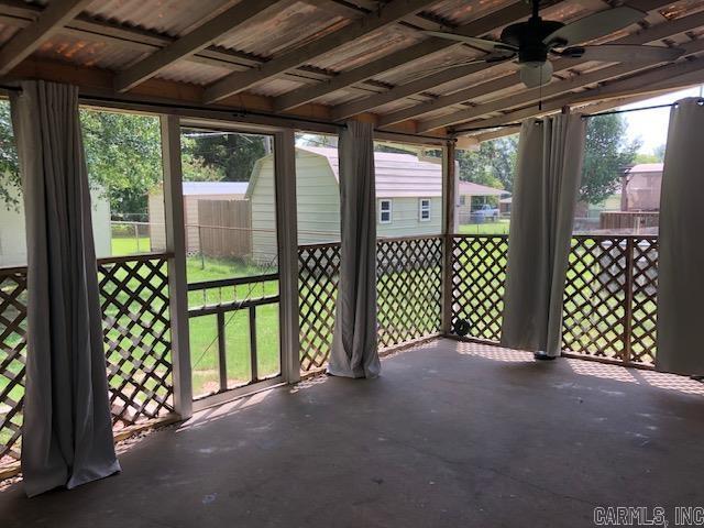 unfurnished sunroom featuring a ceiling fan