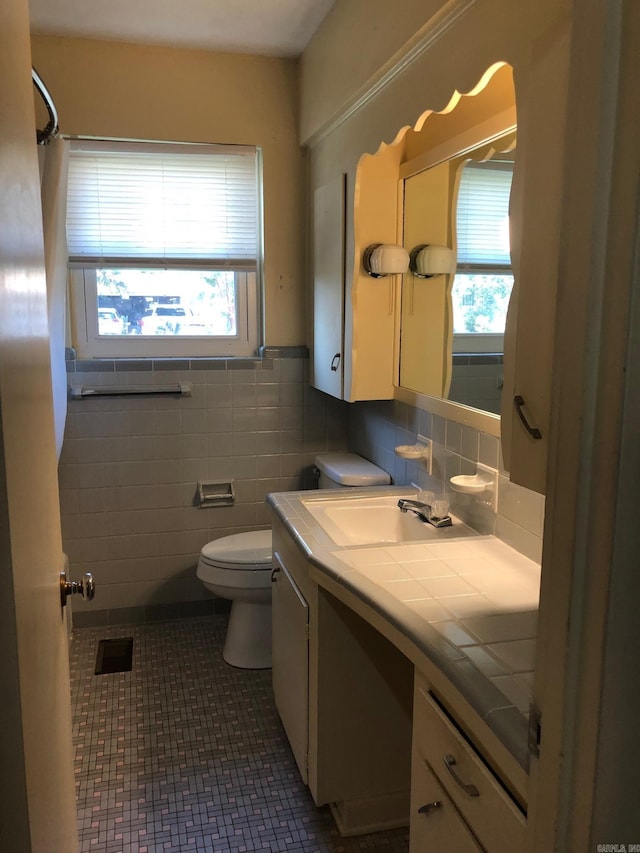 bathroom featuring visible vents, toilet, tile walls, tile patterned flooring, and vanity