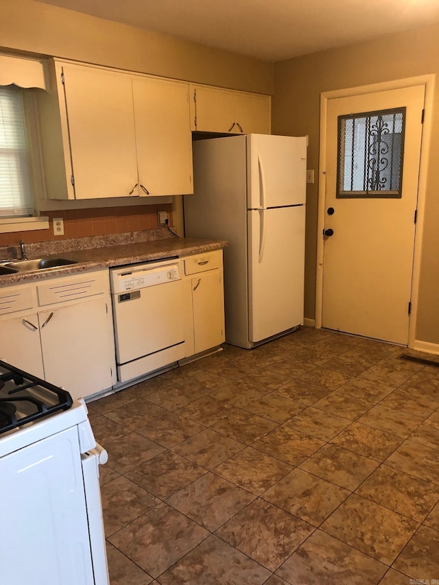 kitchen featuring white cabinets, white appliances, and a sink