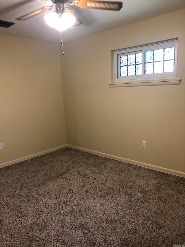 carpeted empty room with visible vents, baseboards, and ceiling fan