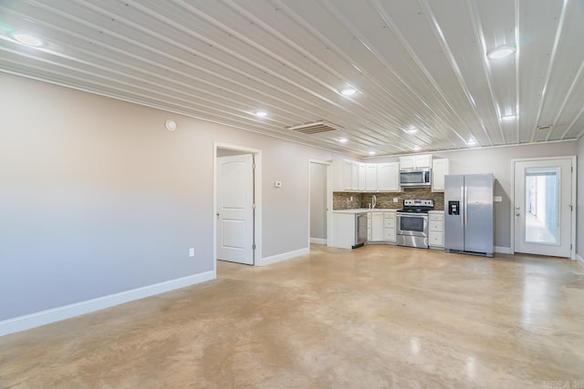 kitchen with baseboards, visible vents, stainless steel appliances, white cabinets, and backsplash