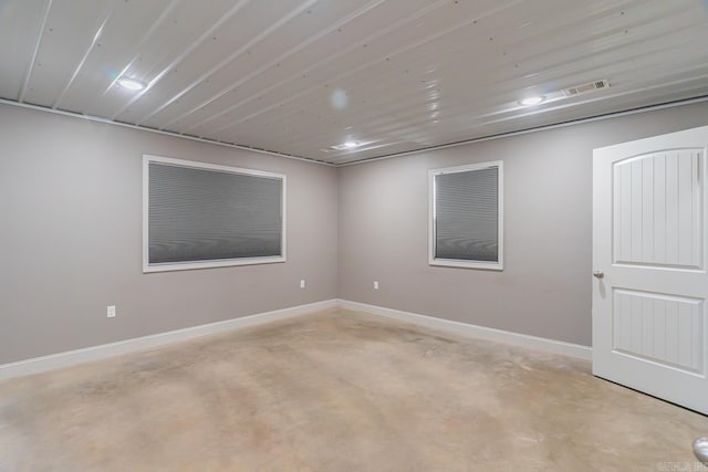 empty room with baseboards and concrete flooring