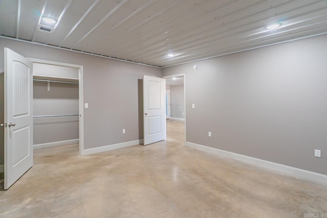 unfurnished bedroom featuring a closet, visible vents, baseboards, and concrete flooring