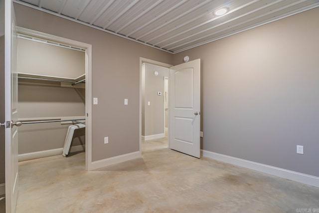 unfurnished bedroom with a closet, baseboards, and concrete floors