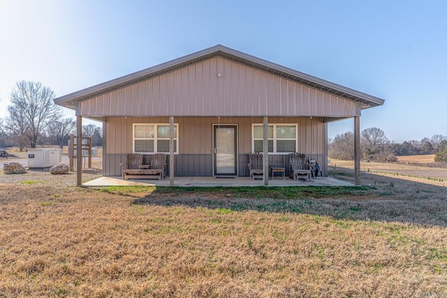 back of property featuring a porch and a yard