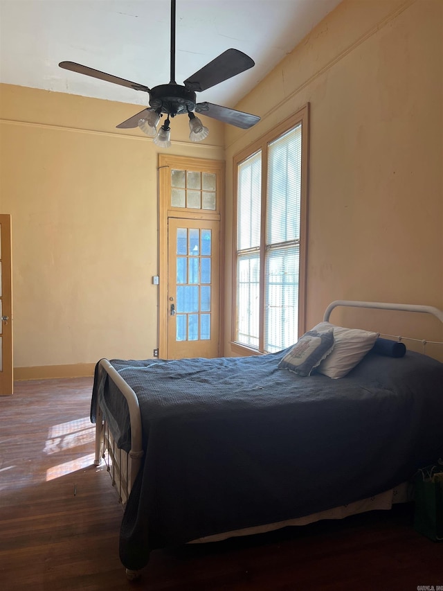 bedroom with baseboards, wood finished floors, and ceiling fan