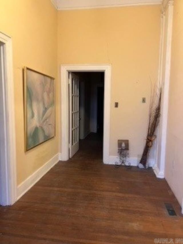 corridor featuring visible vents, wood finished floors, and crown molding