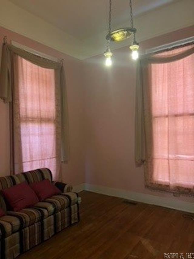 unfurnished living room featuring baseboards and wood finished floors