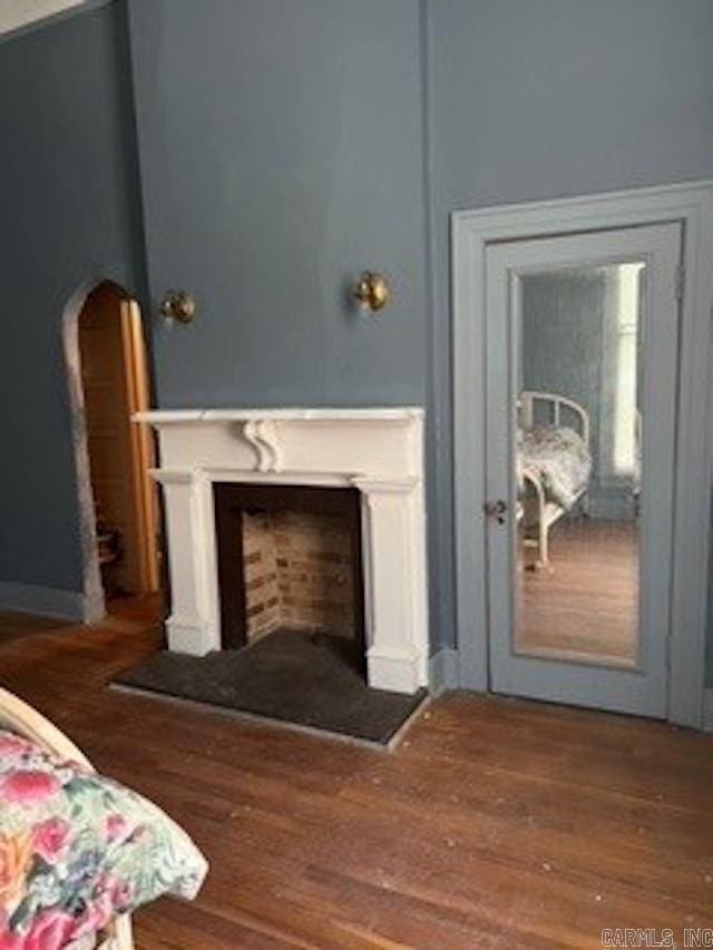 interior space featuring a fireplace with raised hearth and wood finished floors