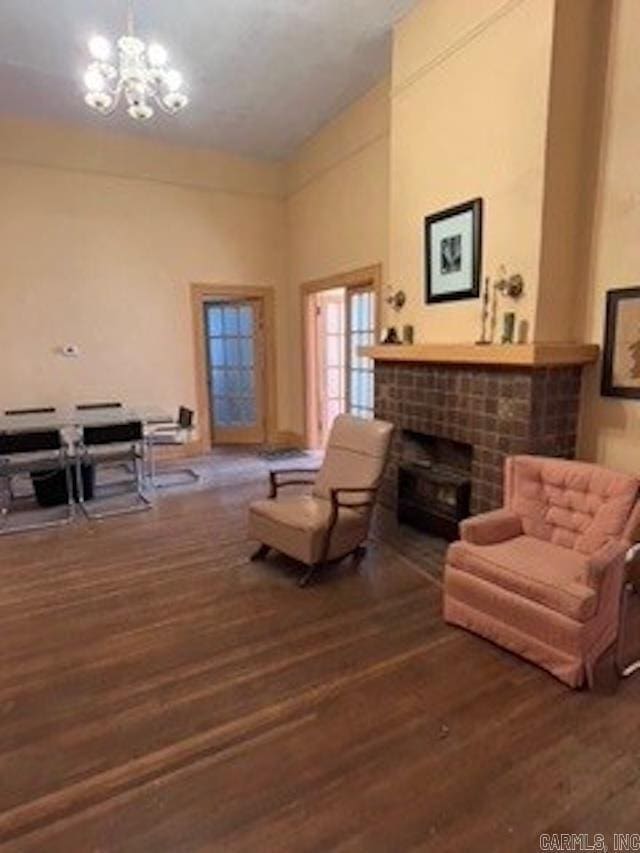 living room featuring a notable chandelier, high vaulted ceiling, a fireplace, and wood finished floors