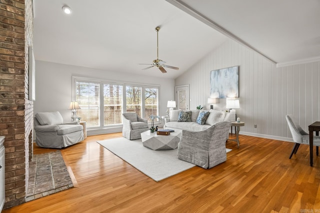 living room with lofted ceiling, a ceiling fan, baseboards, and light wood finished floors