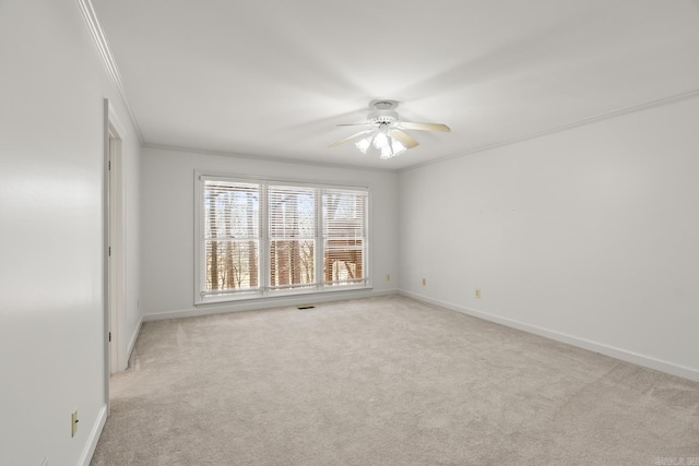 carpeted spare room featuring ceiling fan, baseboards, and ornamental molding