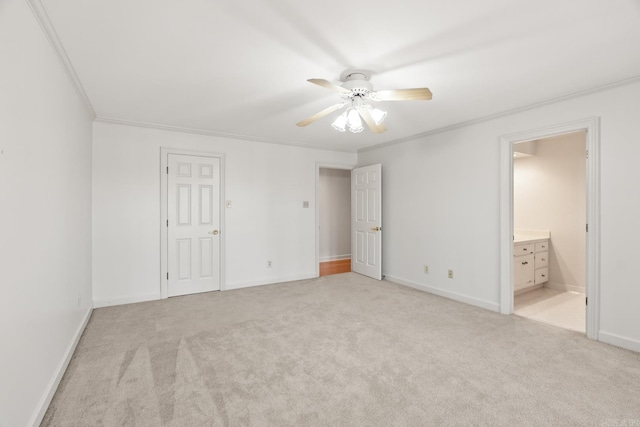 unfurnished bedroom with light colored carpet, connected bathroom, crown molding, and baseboards