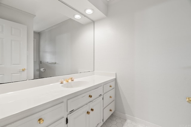 bathroom featuring tile patterned flooring, vanity, baseboards, and ornamental molding