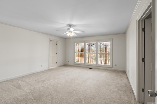 empty room featuring light carpet, ceiling fan, baseboards, and ornamental molding