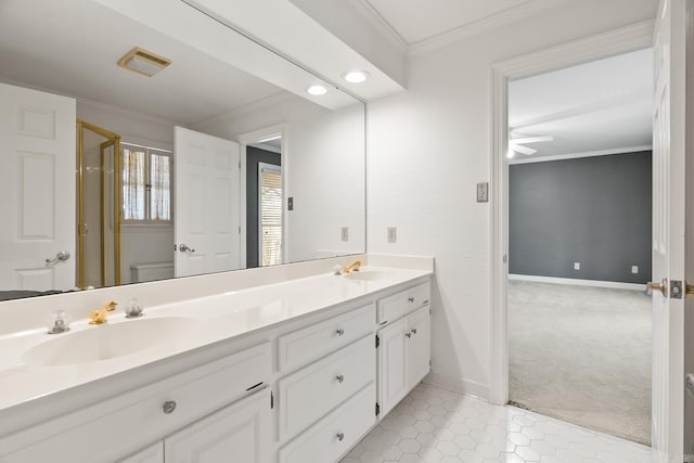 full bathroom featuring baseboards, double vanity, ornamental molding, a stall shower, and a sink