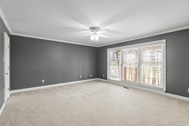 spare room featuring visible vents, light carpet, a ceiling fan, crown molding, and baseboards